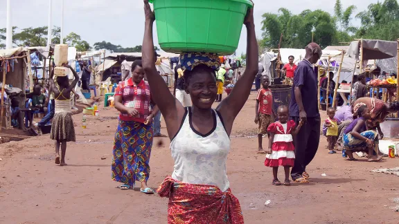 A woman carries water from a barehole installed by the LWF in Cacanda reception center, Northern Angola. Photo: LWF / C. KÃ¤stner