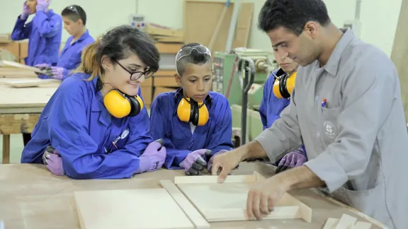 Students watch as a teacher demonstrates a technique in the carpentry workshop. The summer camp encouraged girls and boys to also explore career choices beyond those stereotypically assigned to their gender. Photo: LWF Jerusalem