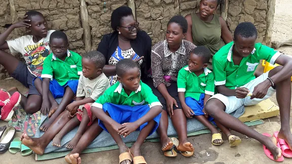 An adult to take charge: Betty Lamunu, center, of LWF Uganda, offered some motherly care to an orphaned family. Photo: LWF Uganda/Z. Asianju