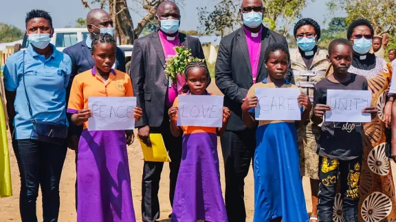 LWF President Archbishop Dr Panti Filibus Musa with LWF Vice-President for Africa Rev. Dr Jeanette Ada Maina, Bishop Theophilus Shadrach of the Lutheran Church of Christ in Nigeria, and LWF staff and students in the Gado camp. The students held signs and recited a poem on the importance of education. All photos: LWF/Lucie Alalu Grinstein