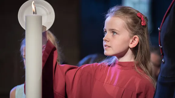 A girl lights a candle at Lund Cathedral, signifying one of the five ecumenical imperatives. Photo: LWF/Albin Hillert