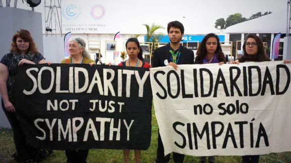 Standing together for one minute in silent protest, LWF Youth delegates unite with local activists to emphasize the devastating effects of climate change. Photo: LWF/Sean Hawkey