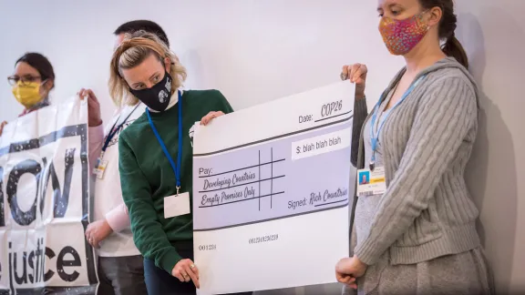 Representatives of faith-based organizations including the ACT Alliance, the LWF and Christian Aid take a stand for just financing at COP26 in Glasgow. Participants presented a large cheque supposedly signed by âRich Countriesâ promising to deliver âEmpty Promises Onlyâ to developing countries, as a sum of âUSD Blah Blah Blahâ. Photo: LWF/Albin Hillert