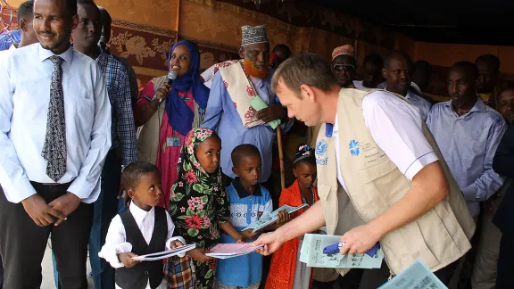 Der LWB-Ländervertreter Lennart Hernender überreicht Erstklässlern die nach dem neuen Lehrplan gestalteten Schulbücher. Foto: LWB Kenia-Dschibuti