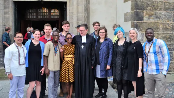 Young reformers at the door of the historic Castle Church in Wittenberg, Germany. Photo: LWF Youth/Edgar Toclo