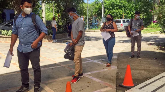 Studierende der Universidad Luterana Salvadoreña stehen Schlange, um ihr LWB-Lebensmittel-Carepaket zu empfangen. Ein Haushalt mit vier oder fünf Personen kann damit etwa drei Wochen auskommen. Foto: LWB/Z. Urbina