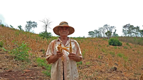 Ein Landwirt in El Salvador zeigt die Auswirkungen einer langanhaltenden Dürre auf seine Maisernte. LWB/C. Kästner