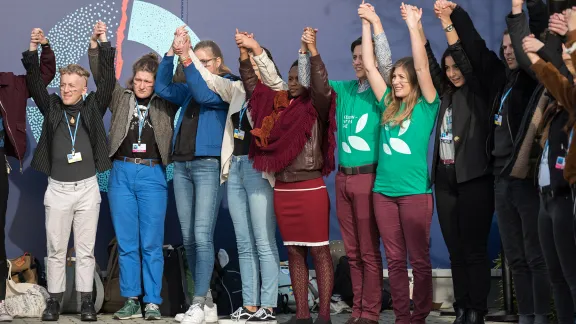 Dressed in green t-shirts reading 'Creation - Not for Sale', Lutheran World Federation delegates Erika Rodning from Canada (right) and Erik Bohm from Sweden (left) join Fridays for Future, as they create a 'human chain', demanding climate justice and urgent action from politicians at COP25 in Madrid. Photo: LWF/Albin Hillert