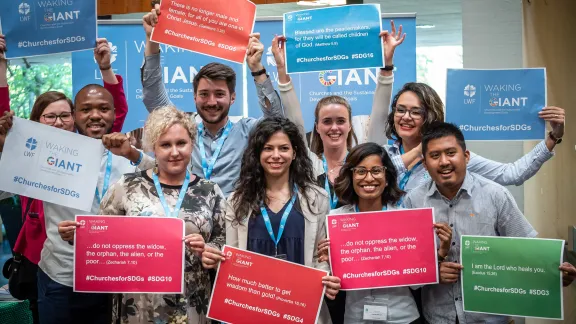 LWF Council youth delegates hold posters at the launch of the Waking the Giant ecumenical initiative in Geneva. Photo: LWF/S. Gallay