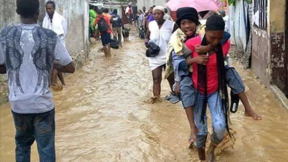 A survivor is carried to safety through a flooded street. Photos: LWF Haiti 