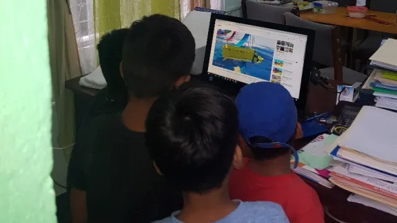 Kinder aus Nicaragua sehen sich im Kirchenbüro ein Video an. Foto: ILCO