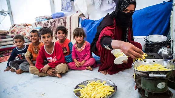 A mother prepares a meal for her children. The family fled from Mosul a few weeks ago and now lives in Debaga camp. All images: LWF/ Seivan Salim