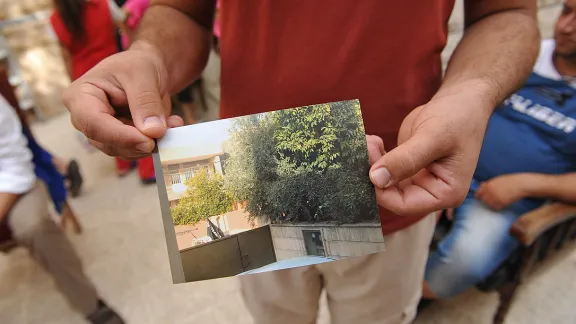 Ein Flüchtling zeigt ein Foto von seinem Haus, welches ihm Nachbarn geschickt haben. Es wurde beschlagnahmt und als Eigentum des ISIS gekennzeichnet. Foto: LWB/M. Renaux