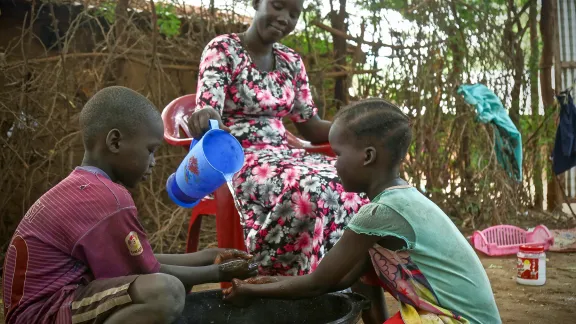 A woman washes her childrenâs hands in Kakuma refugee camp, Kenya. LWF has reinforced hygiene education to prevent a spread of COVID-19 in the camp. Photo: LWF/ P. Omagwa