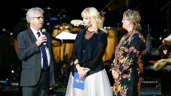 Michel Roy (Caritas Internationalis) die Moderatorin in der Malmö Arena und Maria Immonen (LWB-Weltdienst) bei der Unterzeichnung der Absichtserklärung „Vereint in Hoffnung“. Foto: Mikael Ringlander/Swedische Kirche