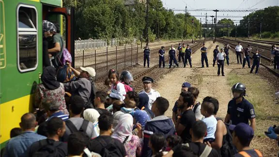 Hungarian police form a cordon as refugees board a train for northern Europe. Photo: MTI