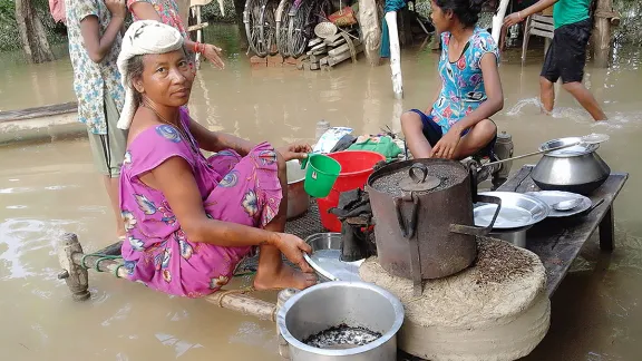 Eine Frau aus der Gemeinde Bhajani, im Bezirk Kailali im äußersten Westen Nepals, bereitet an einer überschwemmten Kochstelle Essen zu. Fotos: LWB/P. Maharjan