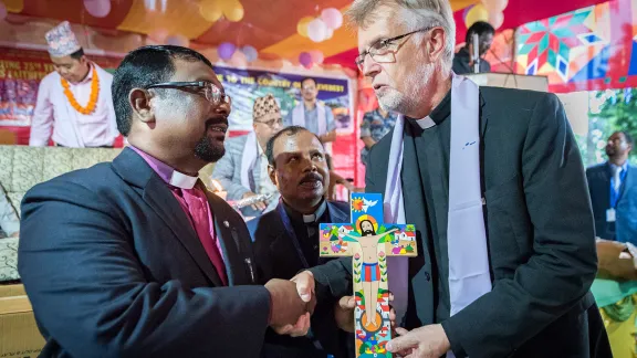 LWF general secretary Rev. Dr Martin Junge (right) offer a Latin American cross as a gift to the Nepal Evangelical Lutheran Church, handing it to NELC president Rev. Joseph Soren (left) and NELC general secretary Rev. Patras Marandi (centre). Photos: LWF/Albin Hillert