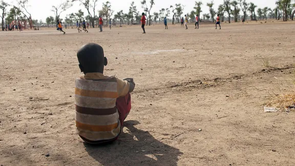 Ein Junge sieht einem Fussballspiel in einem Kinderzentrum zu. Gendrassa-Flüchtlingslager, Südsudan. Foto: LWB/ C. Kästner