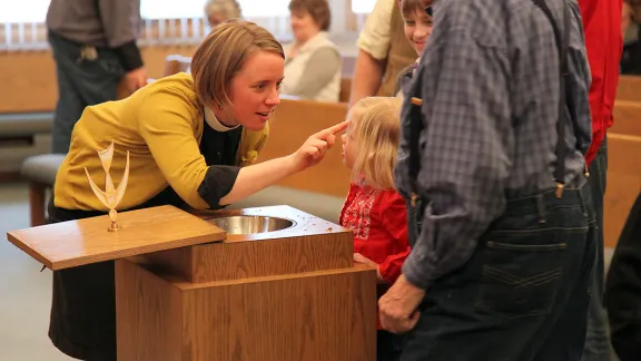 Rev. Taryn Montgomery making the sign of the cross on her daughter's forehead at the Bread of Life Lutheran Church in Minot, North Dakota, United States. Photo: ELCA