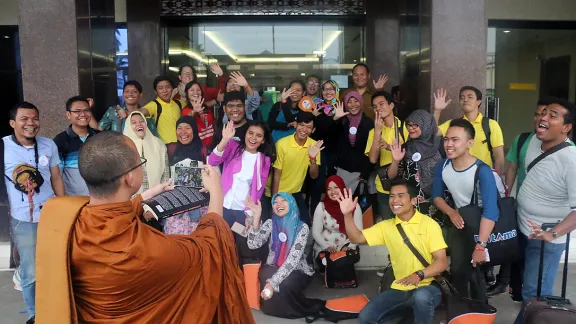 Monk Dhirapunno takes a group photo in front of the conference center in Medan. Photo: A. Yaqin