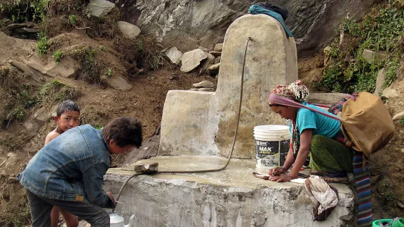 Ein Kind stillt seinen Durst an der Wasserstation, die der LWB Nepal und seine lokale Partnerorganisationen HURADEC im zur Gemeinde Jiri zählenden Dorf Pattitar gebaut haben. Foto: LWB/M. Timsina