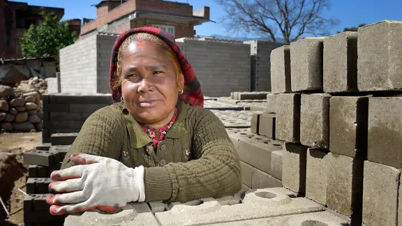 A woman rests from stacking bricks in Sanogoan, Kathmandu valley. Photo: ACT Alliance/Paul Jeffrey