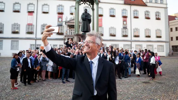 LWF General Secretary Martin Junge taking a selfie of himself, the old reformer Martin Luther and the young reformers on a square in Wittenberg. Photo: LWF/Marko Schoeneberg