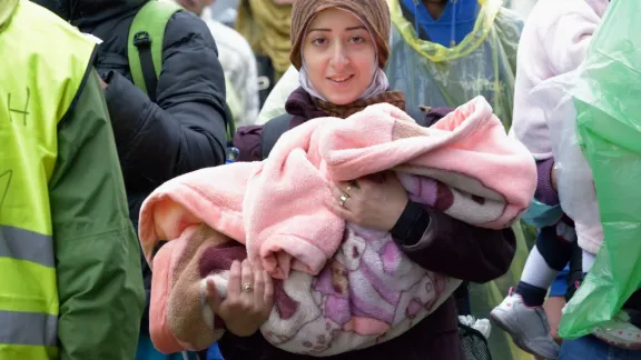 Eine junge Frau nähert sich mit ihrem Baby der kroatischen Grenze bei Berkasovo, Serbien. Hunderrttausende Flüchtlinge, darunter zahlreiche Kinder, durchqueren derzeit Serbien auf ihrem Weg nach Westeuropa. Foto: actalliance/ Paul Jeffrey