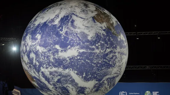 A large globe hanging from the ceiling in the Action Zone of COP26 in Glasgow last November as world leaders gathered to negotiate a response to climate crisis. Photo: LWF/Albin Hillert 