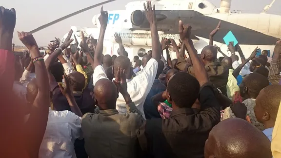 Bei ihrer Rückkehr werden die LWB-Mitarbeitenden am Flughafen Juba von einer Menschenmenge begrüsst. Foto: LWB/E. Mpanya