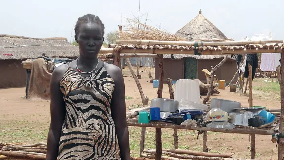 Adhieu Choul beside her drying rack. The mother of six has become an ambassador for good hygiene in the community. Photo: LWF Uganda