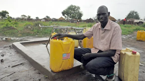 Benjamin, head teacher of Nyumanzi 1 primary school, at the borehole built by LWF with BPRM support next to the school. Photo: LWF/M. Renaux