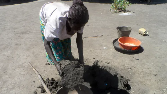 Margret Akot bereitet Lehm für den Bau von Kochherden vor. Foto: LWB-Uganda