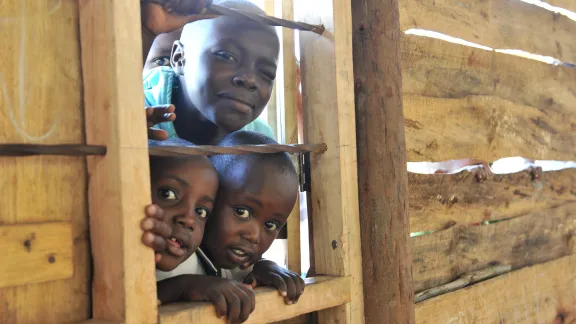 Children looking by a window at the Katalyeba Early Learning Center, in Rwamwanja, Uganda. The center welcomes children from both the host community and the refugee settlement. Photo credit: LWF/M. Renaux