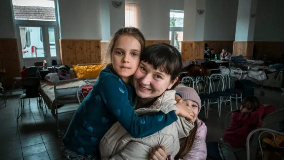 A Ukrainian refugee, Masha, with two of her children, at an aid station at the Ukrainian-Hungarian border on 2 March 2022. Masha, her husband and nine children fled from near the Crimean Peninsula and are receiving aid at a shelter where ACT Alliance member Hungarian Interchurch Aid is assisting Ukrainian refugees. Photo: FCA/Antti YrjÃ¶nen