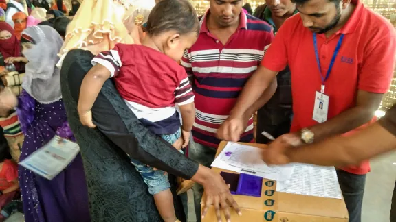 A refugee mother offers her finger print to receive supplementary food items in the refugee camp #18 in Coxâs Bazaar, Bangladesh. Photo: LWF Nepal/Bhoj Raj Khanal