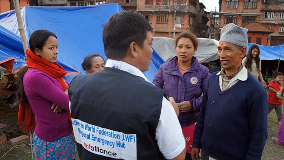 LWF staff member Yadu Lal Shresta (centre), of the LWF Asia emergency hub team, talks to survivors about their living conditions in a camp in Bhaktapur, the worst-affected district of Kathmandu valley. Photo: LWF/C. KÃ¤stner