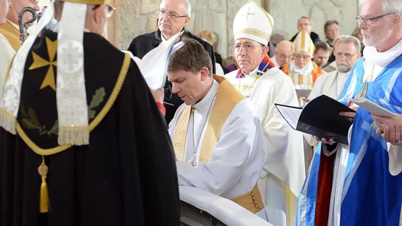 LWB-Präsident Bischof Dr. Munib A. Younan und andere Kirchenleitende führen im Mariendom zu Tallinn den estnischen lutherischen Erzbischof Urmas Viilma (kniend) in sein Amt ein. Foto: Erik Peinar