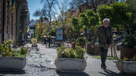 10 October 2022, Kyiv, Ukraine: A man walks through the rubble and shards of glass on the street of Vulytsya Tereshchenkivsʹka in central Kyiv, which hours earlier was hit by a Russian missile. Photo: LWF/ Albin Hillert