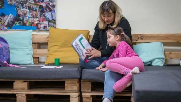 Katiia Kharytoniuk (37) und ihre Tochter Sofija (5) üben gemeinsam das Alphabet. Katiia kam zusammen mit ihren beiden Töchtern aus Uman in der Ukraine nach Polen. Nach einem dreimonatigen Aufenthalt in der Wohnung einer polnischen Familie lebt sie jetzt mit ihren Töchtern in einem Gebäude der Evangelisch-Augsburgischen Kirche in Polen in Beuthen. Der Familienvater bleibt in der Ukraine, da es Männern im Alter von 18 bis 60 Jahren nicht erlaubt ist, das Land zu verlassen. Foto: LWB/Albin Hillert