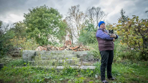 Olena Vedmid and her five-year-old cat Murchik visit what used to be their family home in the village of Bil’machivka. Photo: LWF/ Albin Hillert