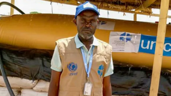 Roger Kalimira, in front of a water bladder he helped install. Photo: LWF/ M. Idjawo