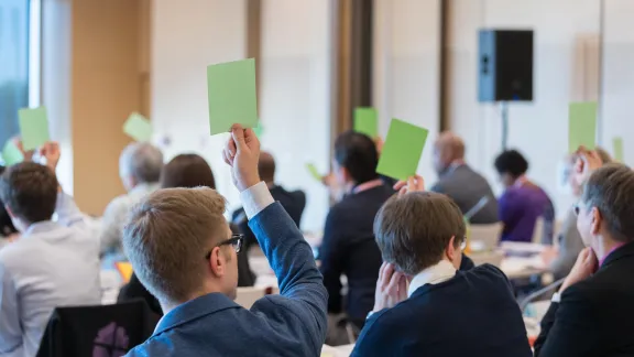 Council Members raise green cards to vote in favor of a motion as the newly LWF Council convenes for their first session following the Lutheran World Federation (LWF) Thirteenth Assembly, held in Krakow, Poland on 13-19 September 2023 under the theme of ’One Body, One Spirit, One Hope’. Photo: LWF/Albin Hillert