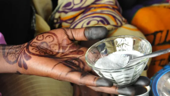 A woman passes sugar in a food place in the market near Kaya refugee camp, Maban county, South Sudan. Photo: LWF/C. Kästner