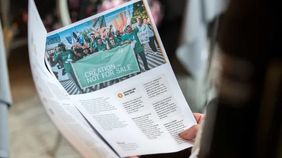 A woman reads a pre-print of the new LWF strategy as presented to the Council. Photo: LWF/Albin Hillert