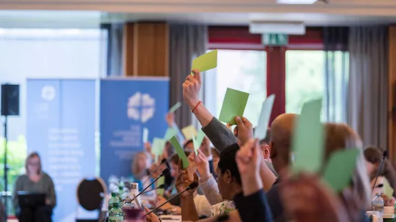 Les membres du Conseil brandissent des cartes vertes pour voter l'approbation de la nouvelle stratégie de la FLM pour la période 2025-2031. Photo : LWF/Albin Hillert