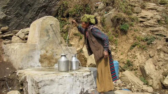 Eine Frau an einem vom LWB gebauten Brunnen. Mit der Wasserversorgung hat die Arbeit des LWB in Nepal begonnen. Foto: LWF/IRW