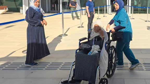 A patient is taken in a wheelchair to buses that drive evacuees from Gaza to Ramon airport. Photo: AVH/LWF Jerusalem