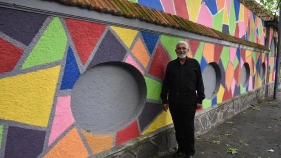 El pastor Dr. Jerónimo Granados junto al mural elaborado por los jóvenes de la comunidad con el apoyo de la Federación Luterana Mundial. Foto:FLM/Eugenio Albrecht